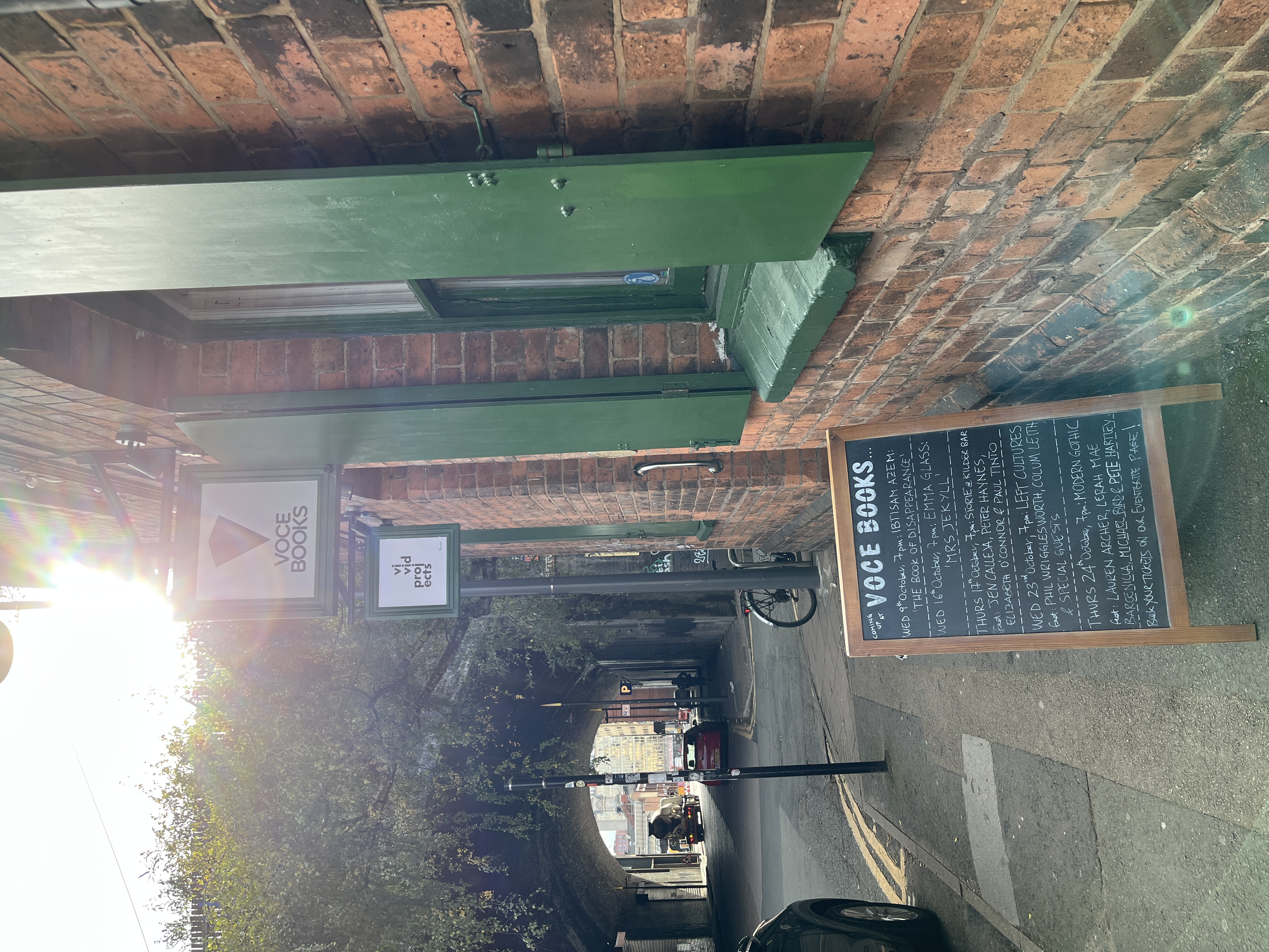 brick wall with green shutters, a display showing the next events at voce books